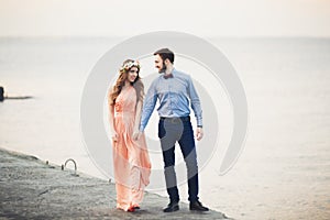 Married wedding couple standing on a wharf over the sea