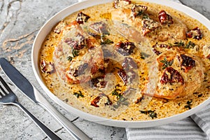 Marry Me Chicken with sun-dried tomatoes, cheese, herbs and aromatic creamy sauce close-up in a plate. Horizontal