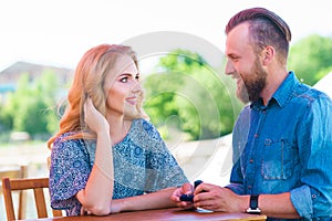 Marry me concept. Loving couple getting engaged in an outdoor cafe.