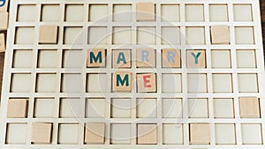 Marry me. Creative proposal concept for everyone. Wooden colourful square puzzles. Marriage concept.