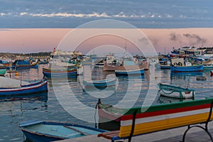 Traditional eyed colorful boats Luzzu in the Harbor of Mediterranean fishing village Marsaxlokk, Malta