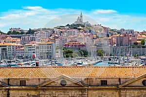 Marseille Old Port with view of the famous Basilica of Notre Dame on top of the hill.