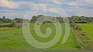 Marshland with meadows and trees under dark storm clouds sin bourgoyen nature reserve, Belgium