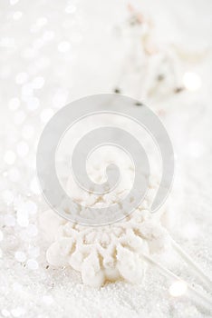 Marshmallow lolly snowflake on white glitter backround