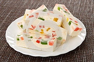 Marshmallow with marmalade in white plate on mat