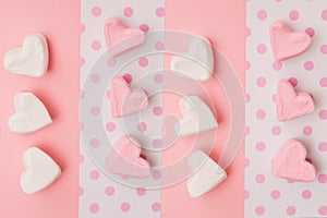 Marshmallow in a row of hearts. Pink and white candies on colored background