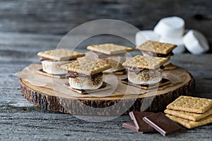 marshmallow smore's on a wooden board, ready for eating.