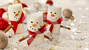 Marshmallow snowmen with snow and gliter, Christmas food background