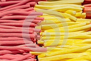 Marshmallow stick red pink yellow, close-up background wallpaper. Sweet candy marmalade in a supermarket. A large pile of fruit