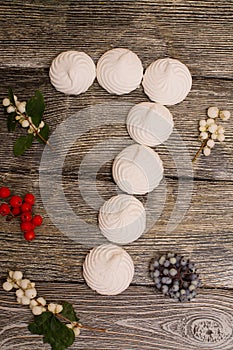 Marshmallows with berries on wooden table. number 7