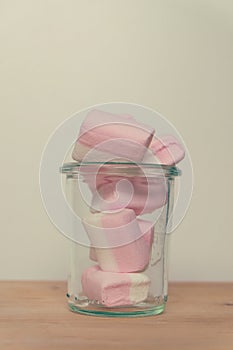 Marshmallows colorful white and pink in glass cup  on white background. Sweet candy dessert.