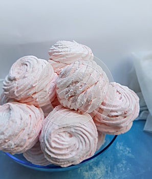 Marshmellows in a bowl on blue background