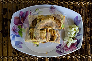 MARTABAK TELUR - stuffed pancake or pan-fried bread Indo-style on a plate, centered