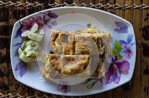 MARTABAK TELUR - stuffed pancake or pan-fried bread Indo-style on a plate, centered from top