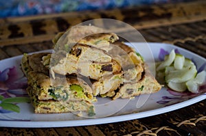 MARTABAK TELUR - stuffed pancake or pan-fried bread Indo-style on a plate, close-up
