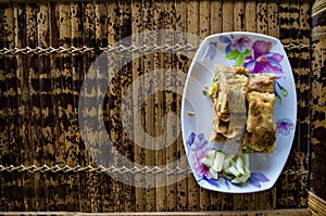 MARTABAK TELUR - stuffed pancake or pan-fried bread Indo-style on a plate, copy-space left
