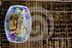 MARTABAK TELUR - stuffed pancake or pan-fried bread Indo-style on a plate, copy-space right