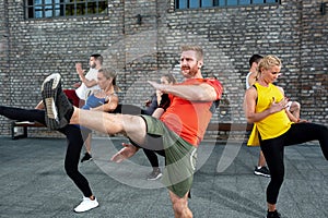 Martial art fitness coach teaching his students frontal leg kicks