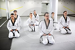 Martial artists wearing black belt, taekwondo and para-taekwondo athletes training together