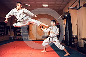 Martial arts masters practice kick in jump