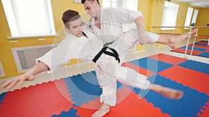 Martial arts. Two athletic men training their aikido skills in the studio. Hitting the opponent in the arm and throwing