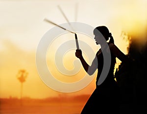 Martial arts, women and nunchaku in hands silhouette in sunset photo
