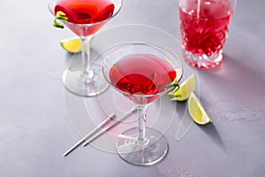 Martini cocktail with cranberry juice garnished with lime twist