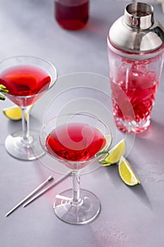 Martini cocktail with cranberry juice garnished with lime twist