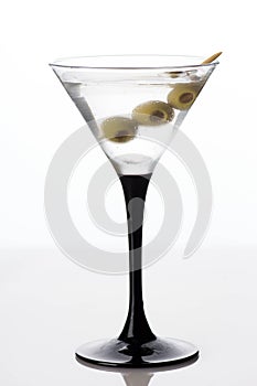 Martini glass and alcohol with green olives isolated