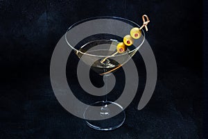 Martini. A glass of dirty martini cocktail with vermouth and olives, a drink