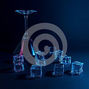 Martini glass with ice cubes in neon holographic vibrant pink and blue colors. Minimal celebration concept