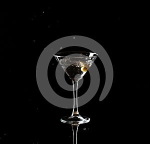 Martini in glass with olives on dark background