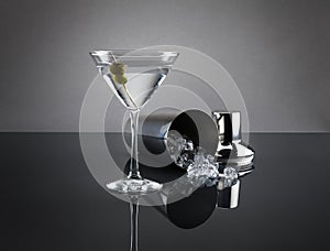 Martini glass and shaker on grey background