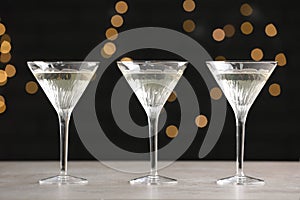Martini glasses of refreshing cocktails on light grey table