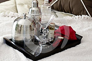 Martini shaker on tray laying on bed