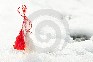 Martisor and Baba Marta. Symbols of spring. of rope on a snow background. Wallpaper of spring flowers and martenitsa