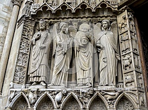 Martyr Saint Denis holding his head over the Portal of the Virgin, Notre-Dame de Paris cathedral, Paris