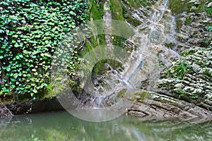 Marvellous cliffs covered with ivy and moss with flowing waterfall