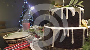 Marvelous festive cozy Christmas tree atmosphere in dining room with ginger cake on New Year celebration dinner table