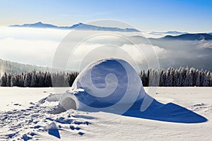 Marvelous huge white snowy hut, igloo the house of isolated tourist is standing on high mountain.