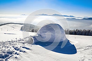 Marvelous huge white snowy hut, igloo the house of isolated tourist is standing on high mountain far away from the human eye.
