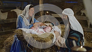 Mary and Joseph speaking and taking care of baby Jesus