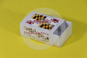 Maryland flag on white box with barcode and the color of state flag on yellow background, paper packaging for put match or