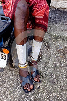 Masai cultural male sitting on his motorcycle with his traditional clothing on