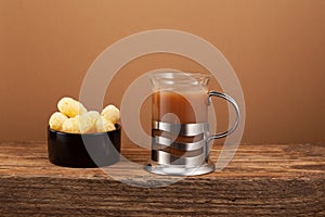 Masala chai or Ginger tea with milk and spicy spices on brown background