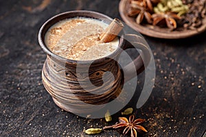 Masala pulled tea chai latte homemade hot Indian sweet milk spiced drink, ginger, fresh spices and herbs blend