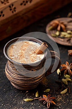 Masala pulled tea chai latte hot Indian sweet milk spiced drink, nutmeg, fresh spices and herbs blend
