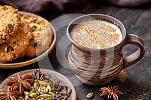 Masala pulled tea chai latte traditional hot Indian sweet milk spiced drink, ginger, fresh spices and herbs blend