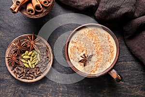 Masala tea chai latte traditional hot Indian sweet milk spiced drink, ginger, cinammon sticks, fresh spices blend