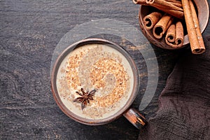 Masala tea chai latte traditional warm Indian sweet milk spiced drink, ginger, cinammon sticks, spices blend organic